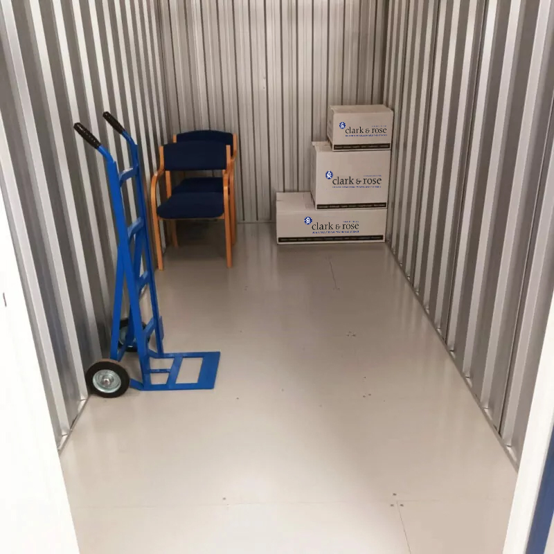 Boxes, chairs and a trolley inside a medium size storage unit