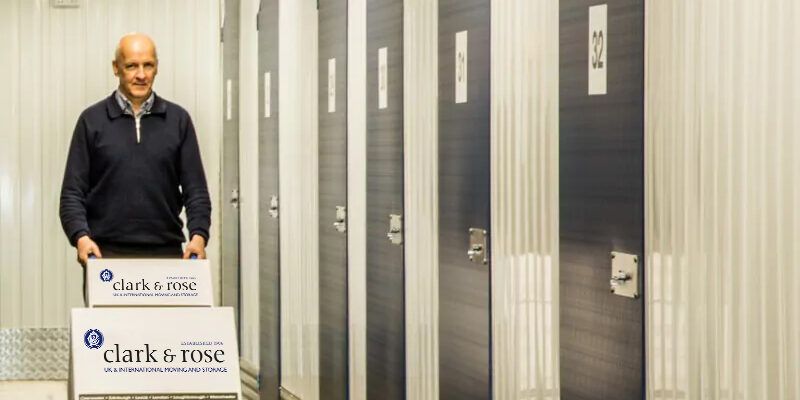 Man using a trolley to move boxes into indoor storage units